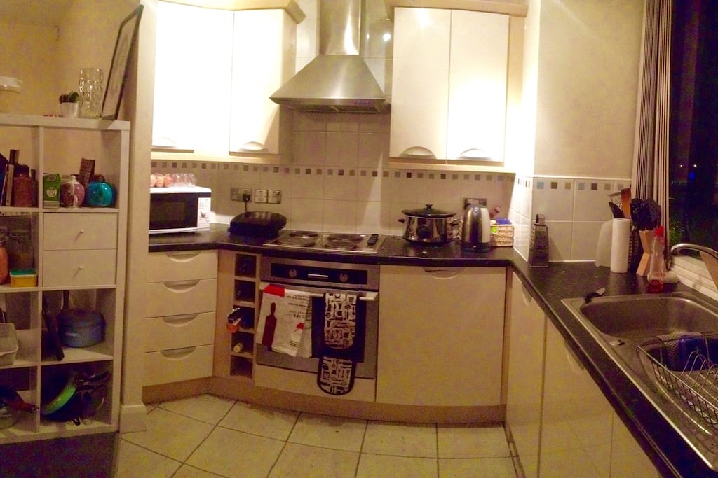 Kitchen with hobs, oven, microwave, slowcooker, grill and lots of pots and pans