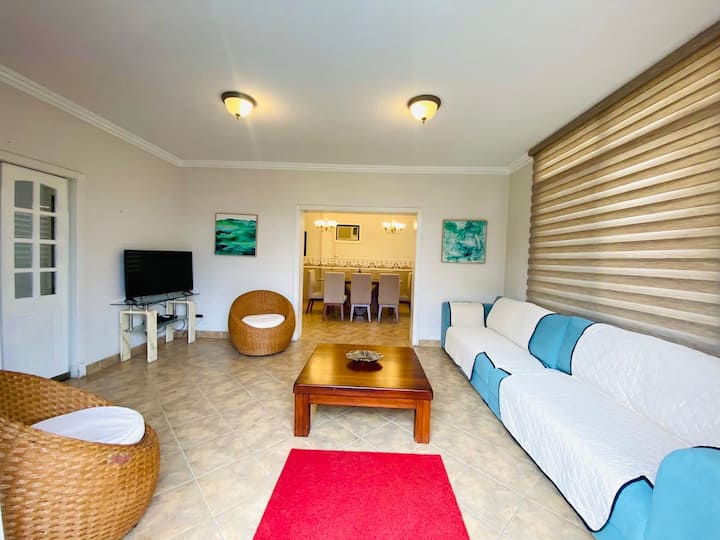 ห้องนั่งเล่นถ่ายรูปมองเห็นห้องรับประทานอาหารและทางออกไปยังสระว่ายน้ำ 