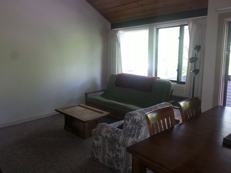 Living room/dining room combo, includes gas fireplace, and balcony looking out to Loon Mountain