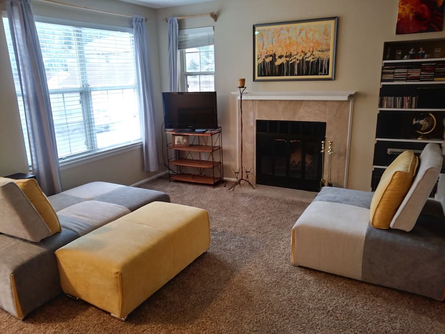 Spacious living area with lots of natural light and a wood burning fireplace.