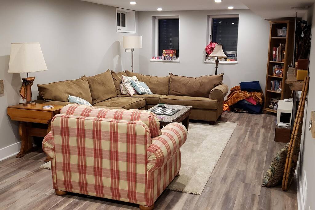 Half of the studio apartment. The sectional couch pulls out into a queen size bed. The plaid chair pulls out to a single bed.