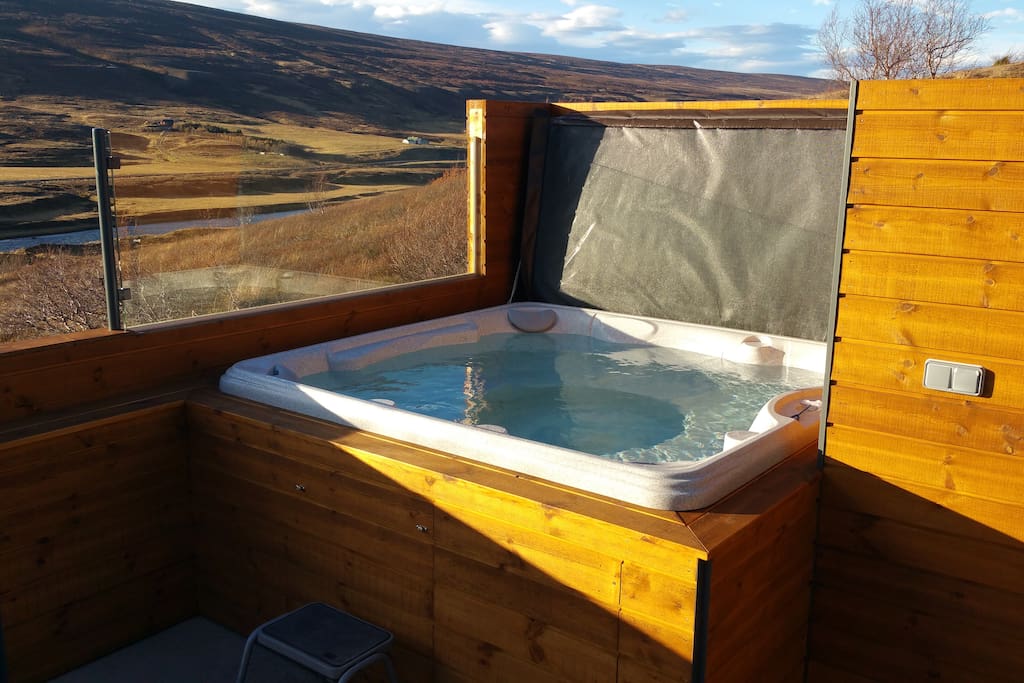 Hot tub spa with an automatic heating system and a shower outside are accessible from upper bathroom