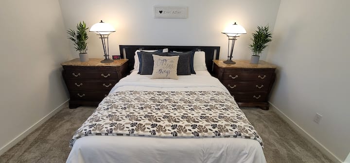 Chambre principale. Lit queen size. Deux grandes commodes /tables de nuit avec lampes. Les lampes sont contrôlées par des interrupteurs lorsque vous entrez dans la pièce. Les lampes peuvent elles-mêmes être tamisées sur les lampes.