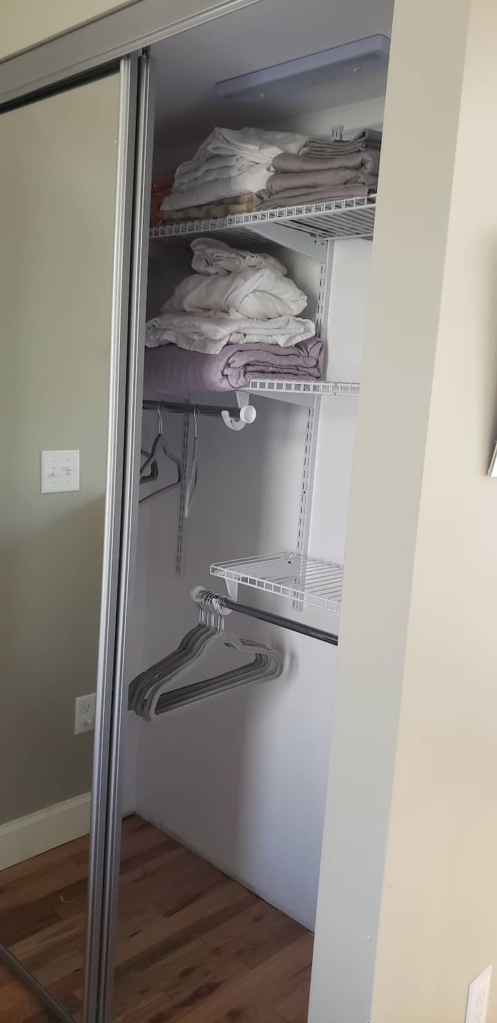 ตู้เสื้อผ้าขนาดใหญ่พร้อมไม้แขวนเสื้อและชั้นวางของ 