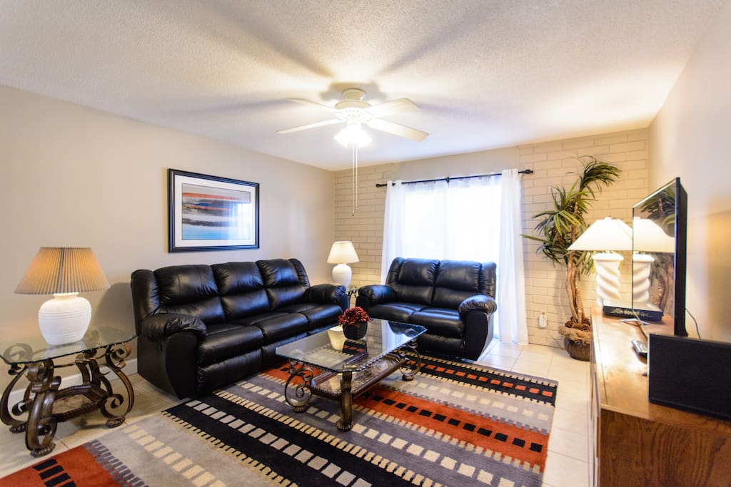 This is the living room with leather reclining loveseat and sofa, 55" flat screen TV and lots of space to relax. Window is draped to allow light and also provide maximum privacy. Lamps adorn the end tables and the picture on the wall captures the color in the rug and dining room.
