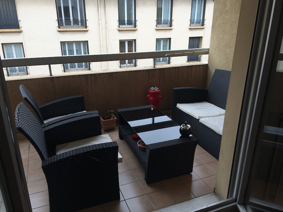 Balcon aménagé avec un canapé et 2 sièges