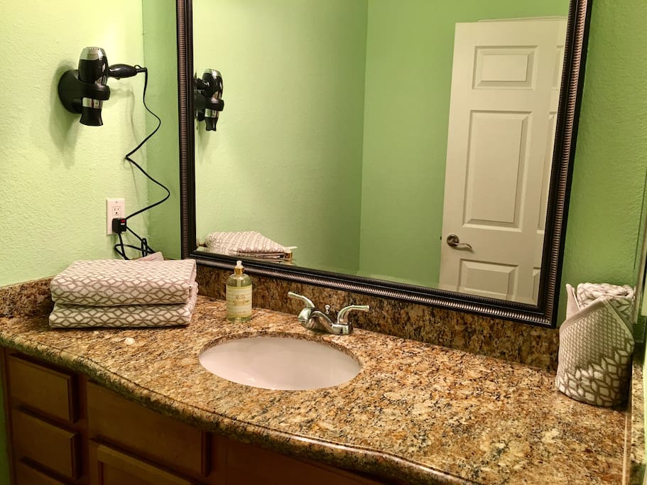 Your Bathroom sink wit granite surface and hairdryer.