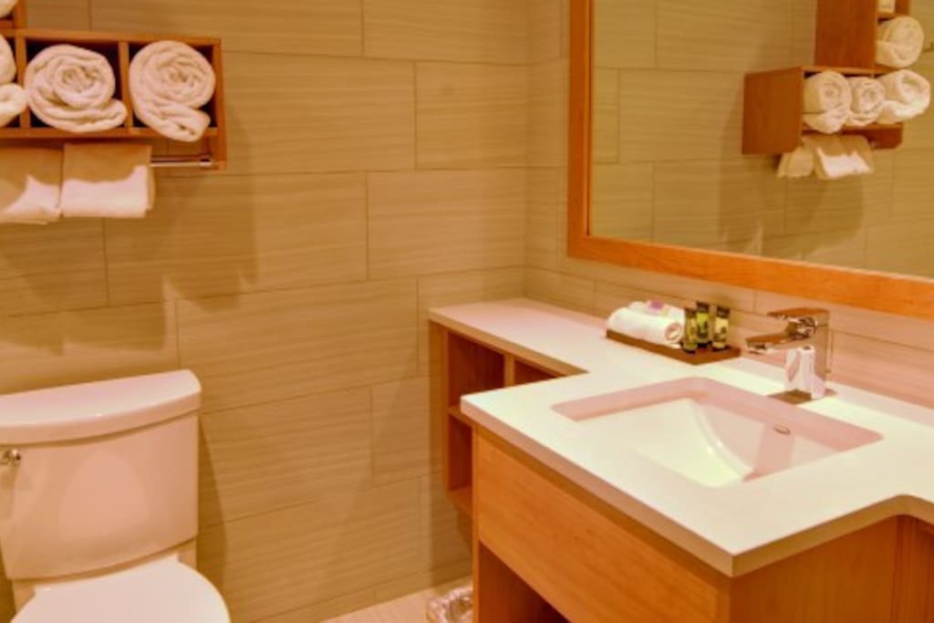 Prepare for your day outside in the spacious bathroom featuring warm wood touches.