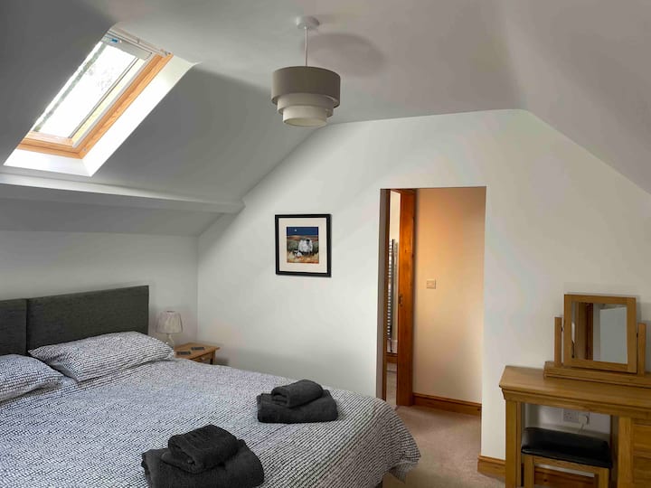 Master bedroom with super king bed, walk-in wardrobe area and ensuite shower room.