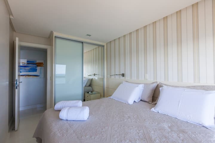 سرير بحجم كبير مع تجهيزات إضاءة السقف وعلى جانبي السرير