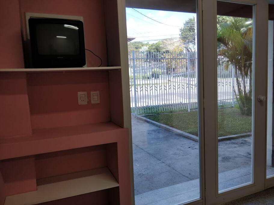 Vista de dentro do Flat para fora com garagem privativa e jardim