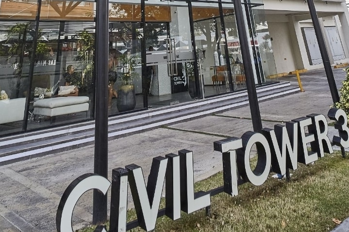 A modern building facade is prominently displayed, featuring large glass windows and double entrance doors. A landscaped area is visible in front, showcasing greenery. The name 'Civil Tower 3' is prominently featured in bold letters, adding to the contemporary aesthetic of the exterior.