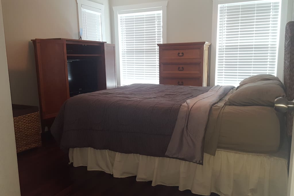 Guest bedroom showing TV and dresser