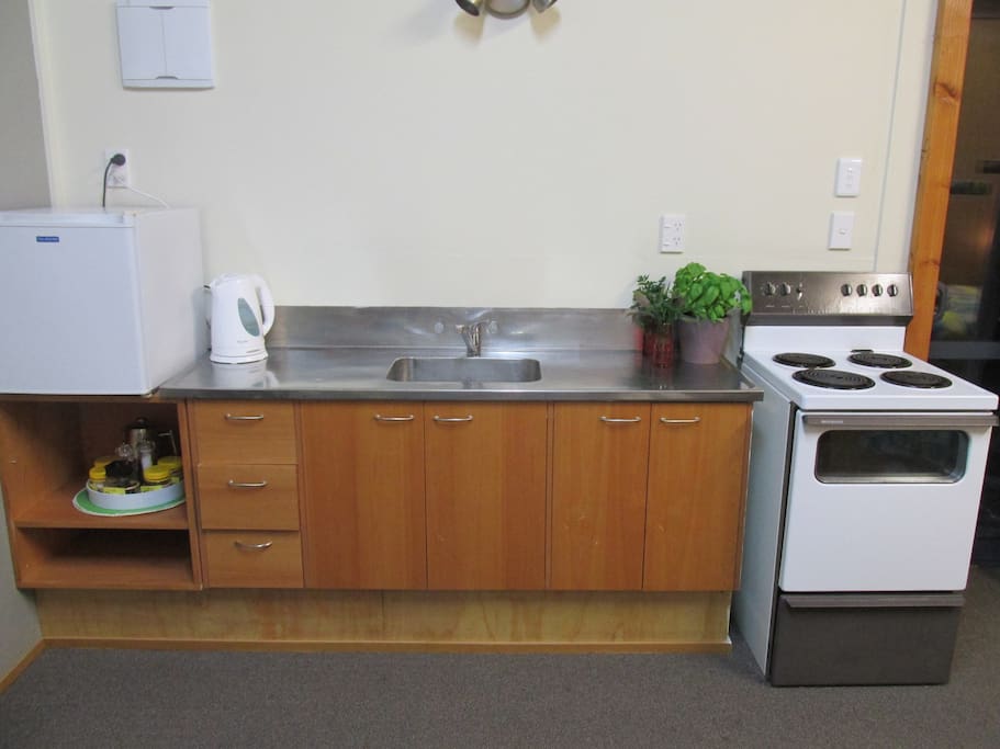 Kitchen includes full oven with cooktop and mini fridge