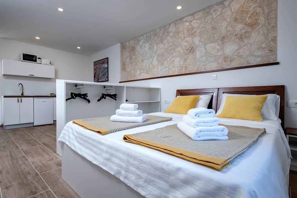 Double bed inside the old stone house, which keeps the temperature nice and cool. The room has A/C and satellite smart TV