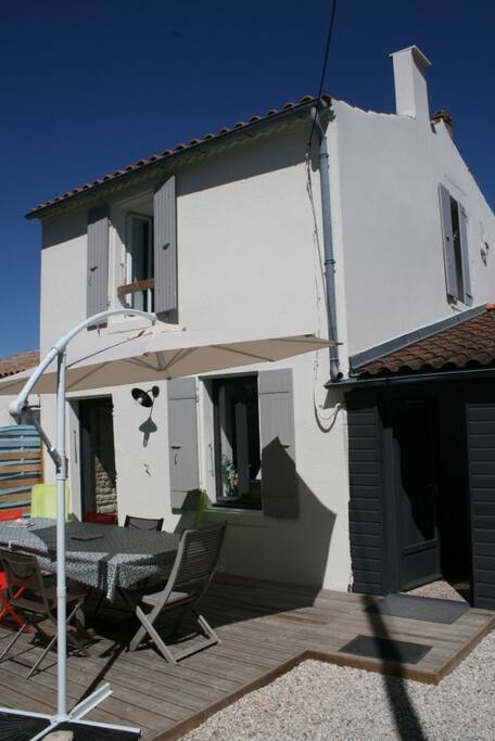 Une partie de la façade de la maison et de la grande terrasse