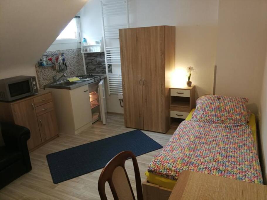 Zimmer Moonlight im Überblick: mit Singleküche, Kühlschrank, Spüle, Mikrowelle auf Utensilienschrank, Bett, Schrank, Nachtschränkchen