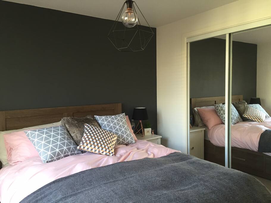 King size bed with a large mirrored built in cupboard