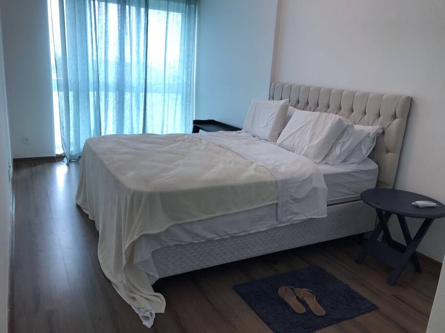 Suíte 01: Com cama de casal super confortável, ar condicionado, cortina e mesinha de apoio.