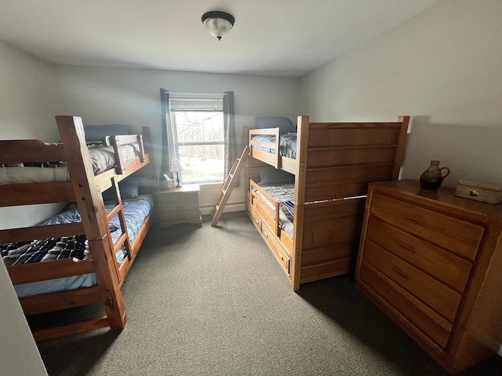 The "kid's room" has two matching bunk beds with a closet and dresser for storage. 