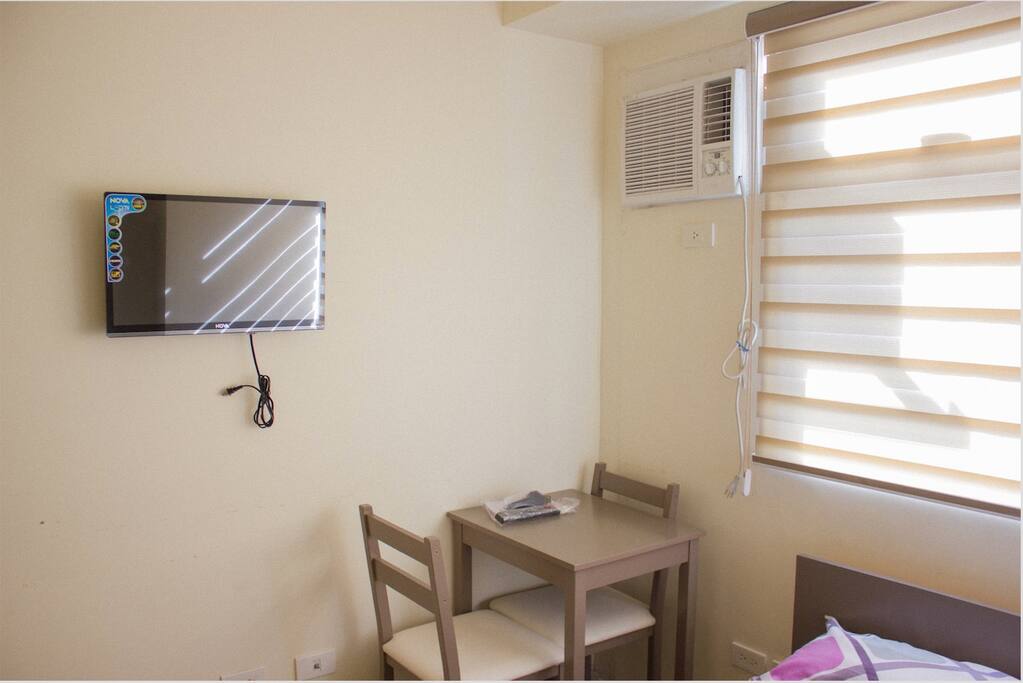24 inch-TV, small desk with 2 chairs, and aircon