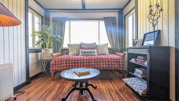 Sunroom ერთად daybed და ექსპანსიური ტბა ხედები.