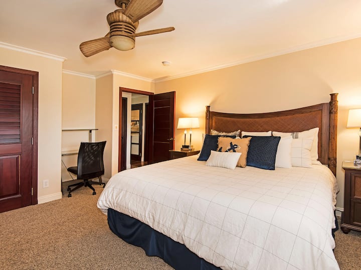 Elegante hoofdslaapkamer met kingsize bed met uitzicht op het zwembad en een eigen badkamer