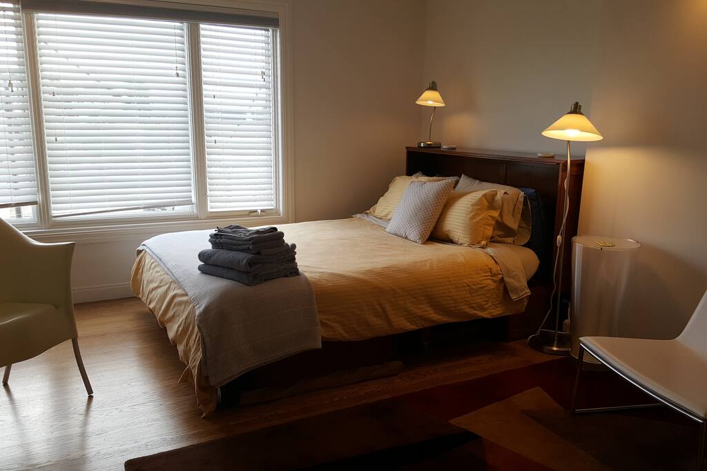 Queen bed by window has spectacular view of city lights downtown.