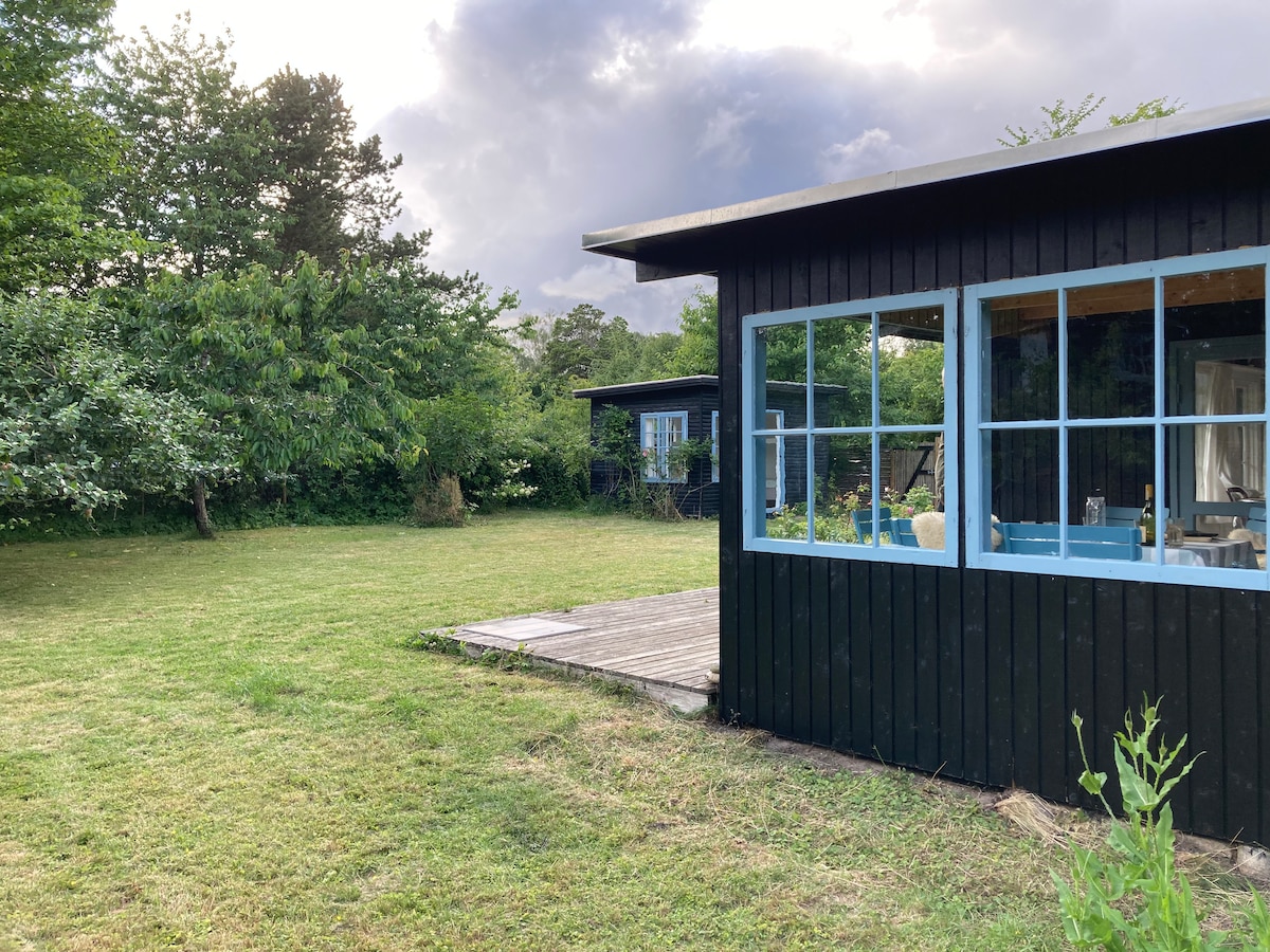 Terraza cubierta y casa de huéspedes al fondo 