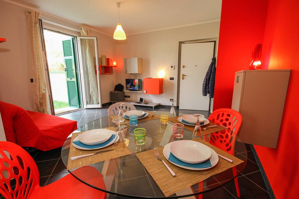 Living room with a dining set, a sleeping sofa for two, a television and kitchen