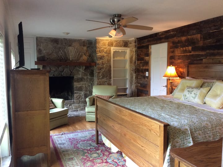 Rozsiahla hlavná spálňa s masívnym dubovým nábytkom, kamennou prácou, stodolovým drevom, šatníkom a vlastnou kúpeľňou.