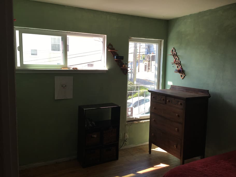 The room is rustic, old wood floors and unfinished window frames. Full-sized bed.