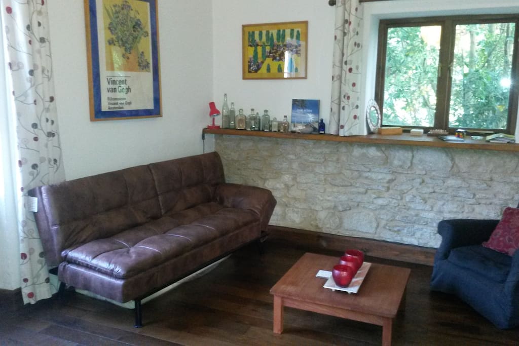 Lounge with original stone wall. Sofabed opens easily to accommodate extra guests. There's a memory foam topper for extra comfort. Size is 120cm x 190cm
