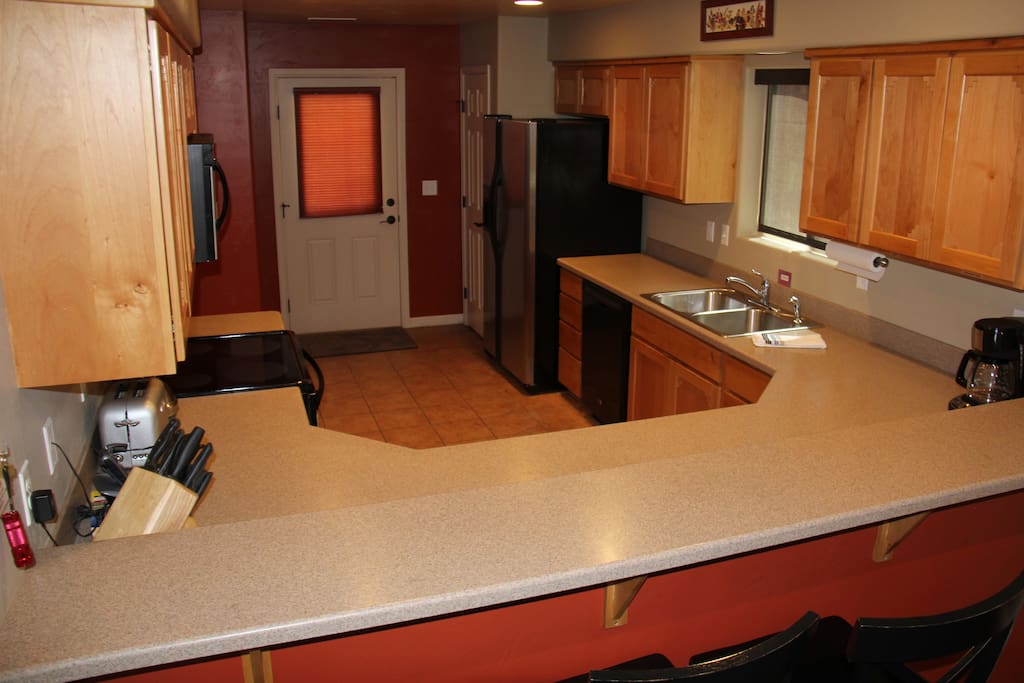 Huge kitchen leads to back patio with bbq grill.