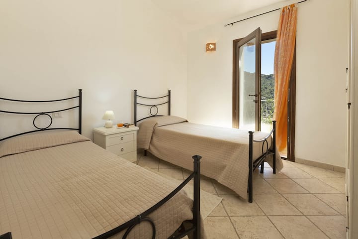 chumba cha kulala cha pili chenye vitanda viwili vya mtu mmoja ambavyo vinaweza kuwa vitanda viwili, vilivyounganishwa na bustani