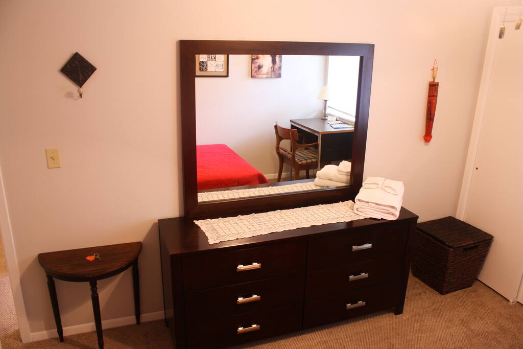 An empty dresser, a large mirror, a hook for your towels, a laundry basket and a side table all available for you to use during your stay.