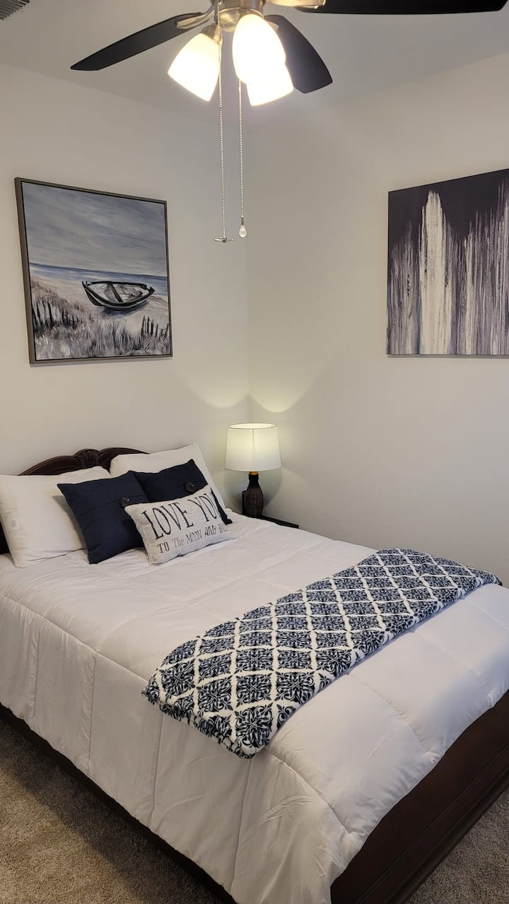 Chambre #2. Matelas Sealy Queen Size flambant neuf. Stand de nuit avec lampe (y compris port de recharge USB). Le placard comprend un porte-bagages et des cintres.