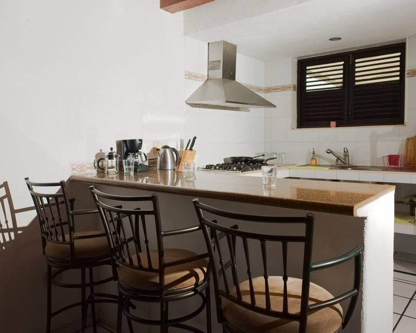 Una amplia barra cubierta con granito y 3 comodos bancos para estar cerca de la cocina.