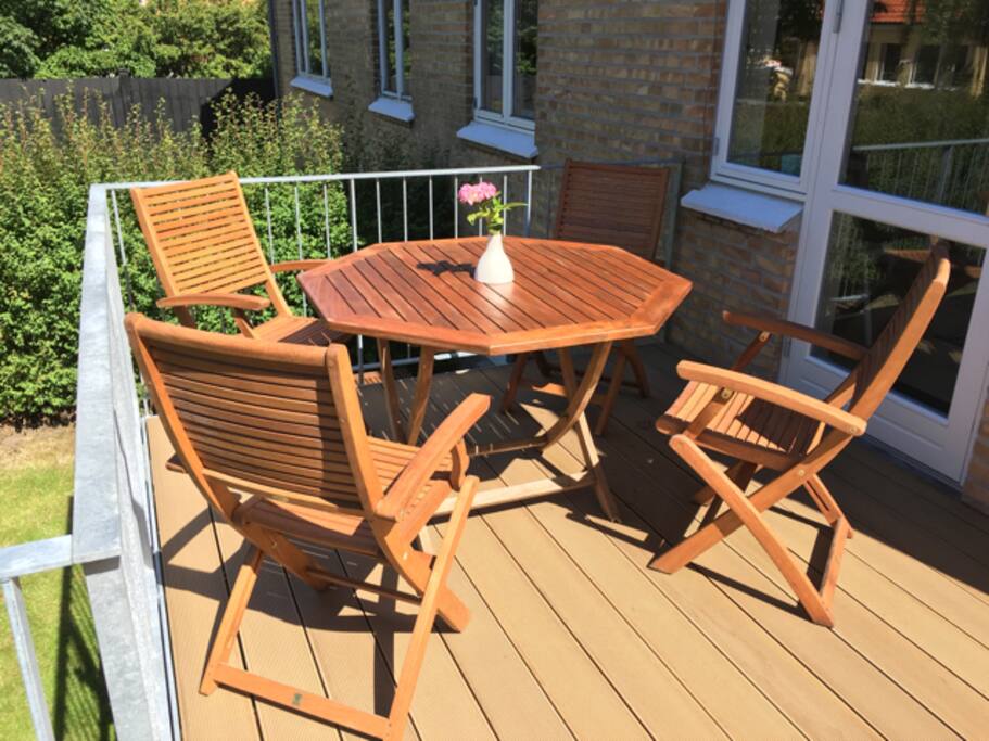 Balkon, der har udgang fra spisestuen og nedgang til have med terrasse og græsplæne