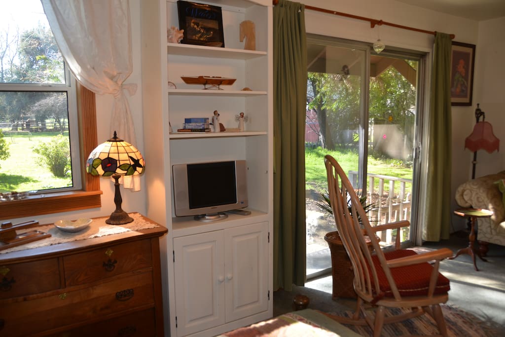 Front window & sliding door views, dresser, TV w/HD antenna, comfortable rocker
