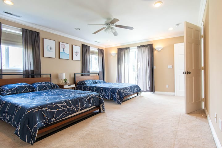 Spacious master bedroom with 2 queen beds and access to the balcony