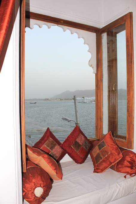 Small couch in the room getting mesmerising view of lake pichola.