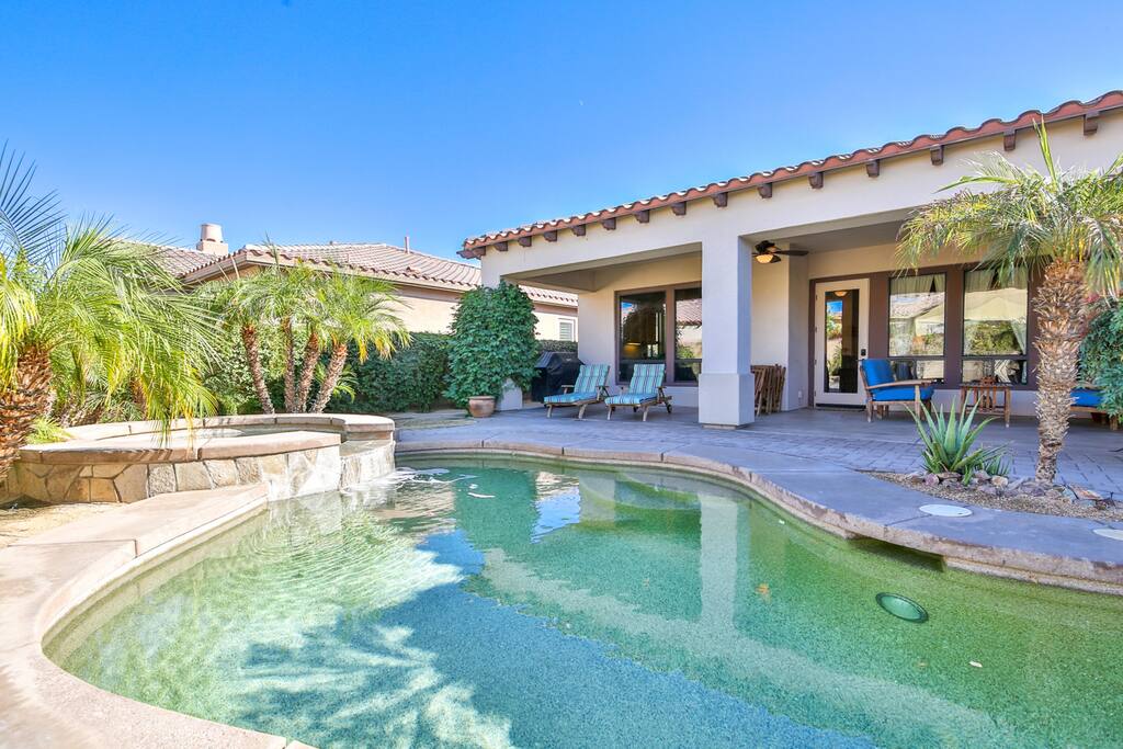 Sparkling private pool with hot tub and lush landscaping.