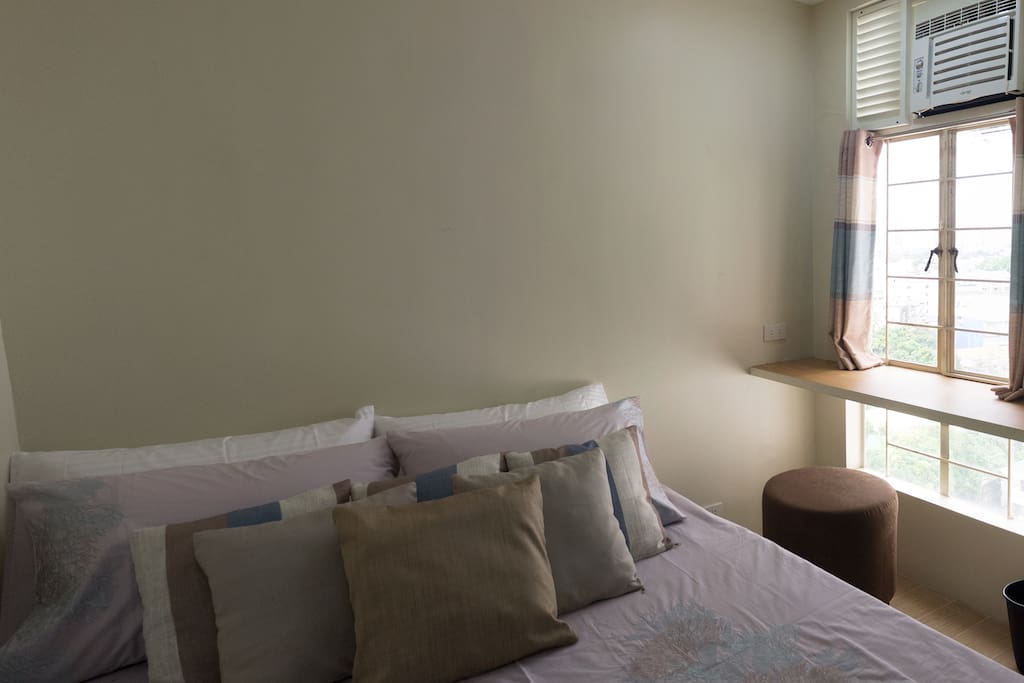 Air-conditioned master bedroom with queen-size bed and workdesk.