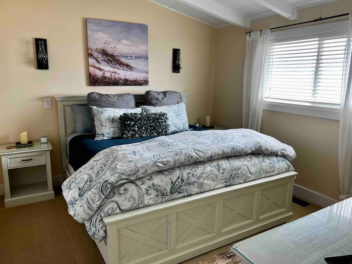 Трета спална соба со брачен кревет и поглед кон океанот.