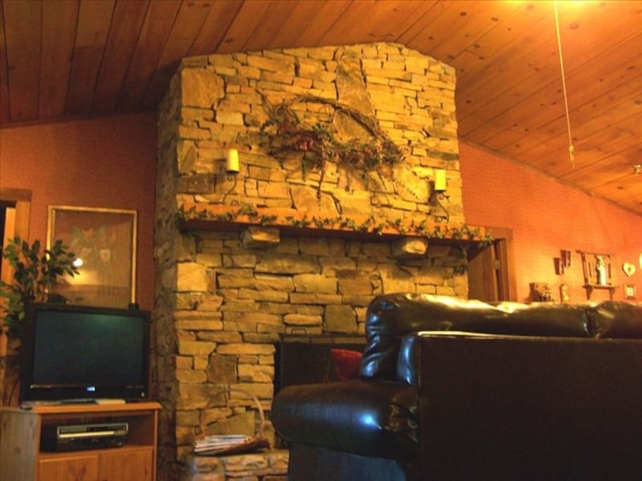 Living room with imposing stack stone wood burning fireplace