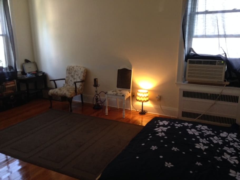 Living room. Has a floor mattress, TV, Chairs, A/C, LP record Player with Classic Records of 70s and 80s.