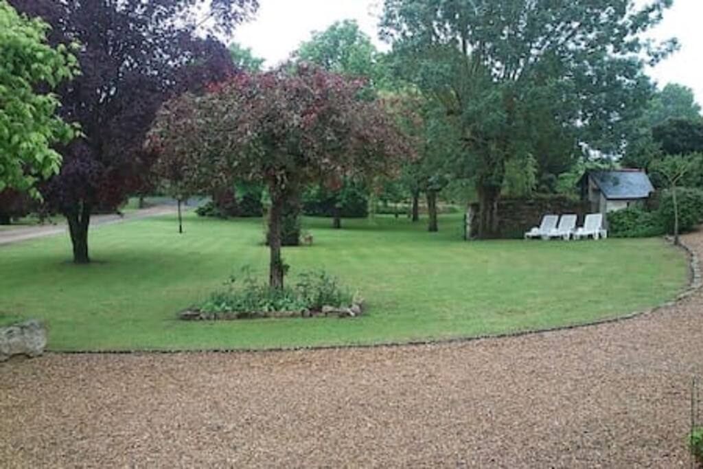 Parc arboré avec volière et stationnement privé.