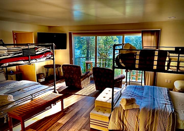 4 queen bunkbeds with a private deck, two armchairs, ottoman, 4K 55" Smart TV and a view of the lake and Kidd Island