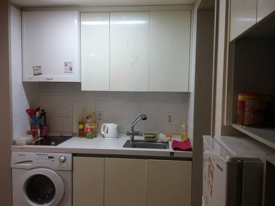 Kitchen with Stovetop, Sink, Utensils, cupboard, and Washer